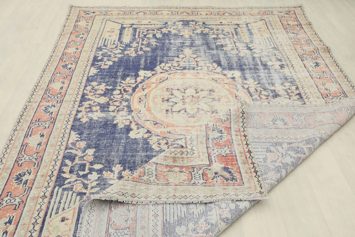 Rug corner folded back to reveal the back of the rug, showcasing the hand-knotted craftsmanship.