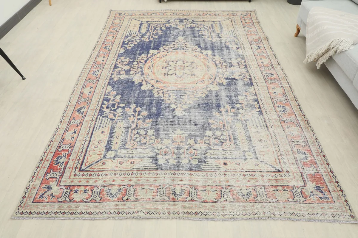 Full overhead view of the navy and rose vintage area rug, showcasing its overall pattern and condition.