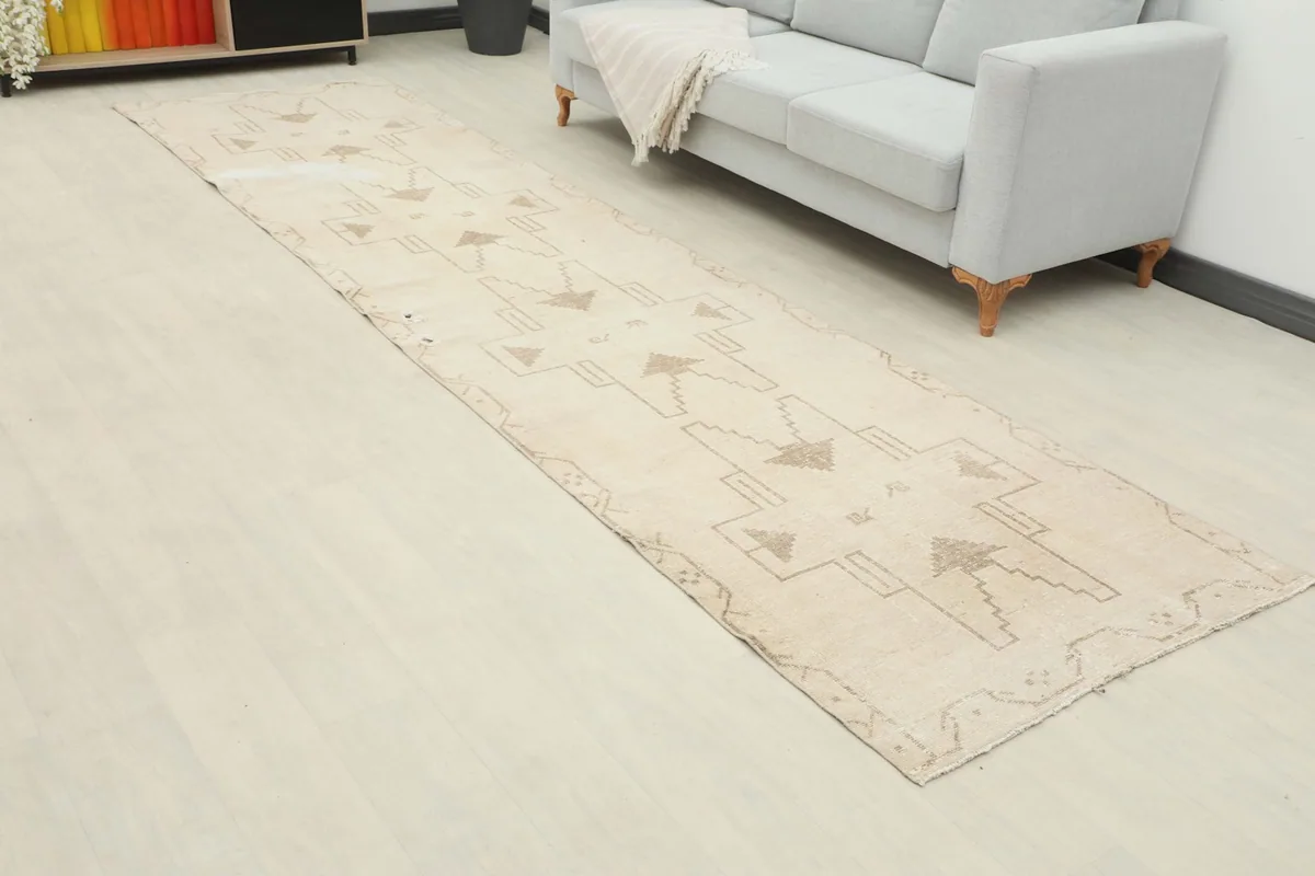 Angled view of the vintage runner rug extending along the floor next to a sofa