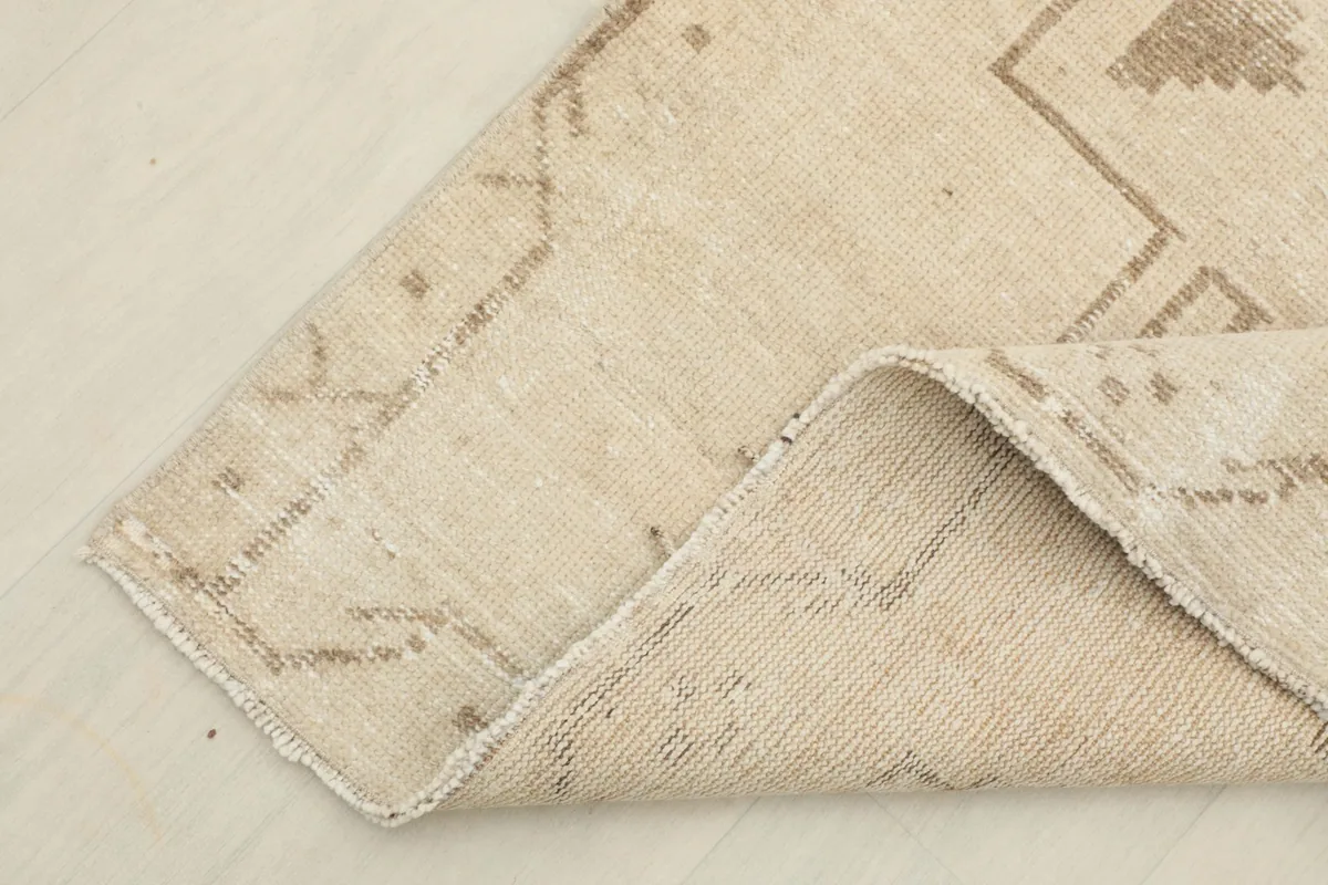 Corner of the rug folded to show the hand-knotted wool pile and cotton foundation