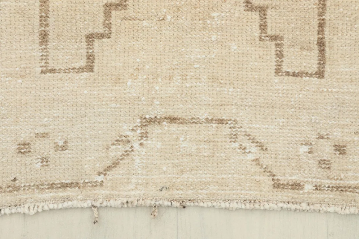 Close-up of the short, natural fringe and the worn edge of the vintage runner