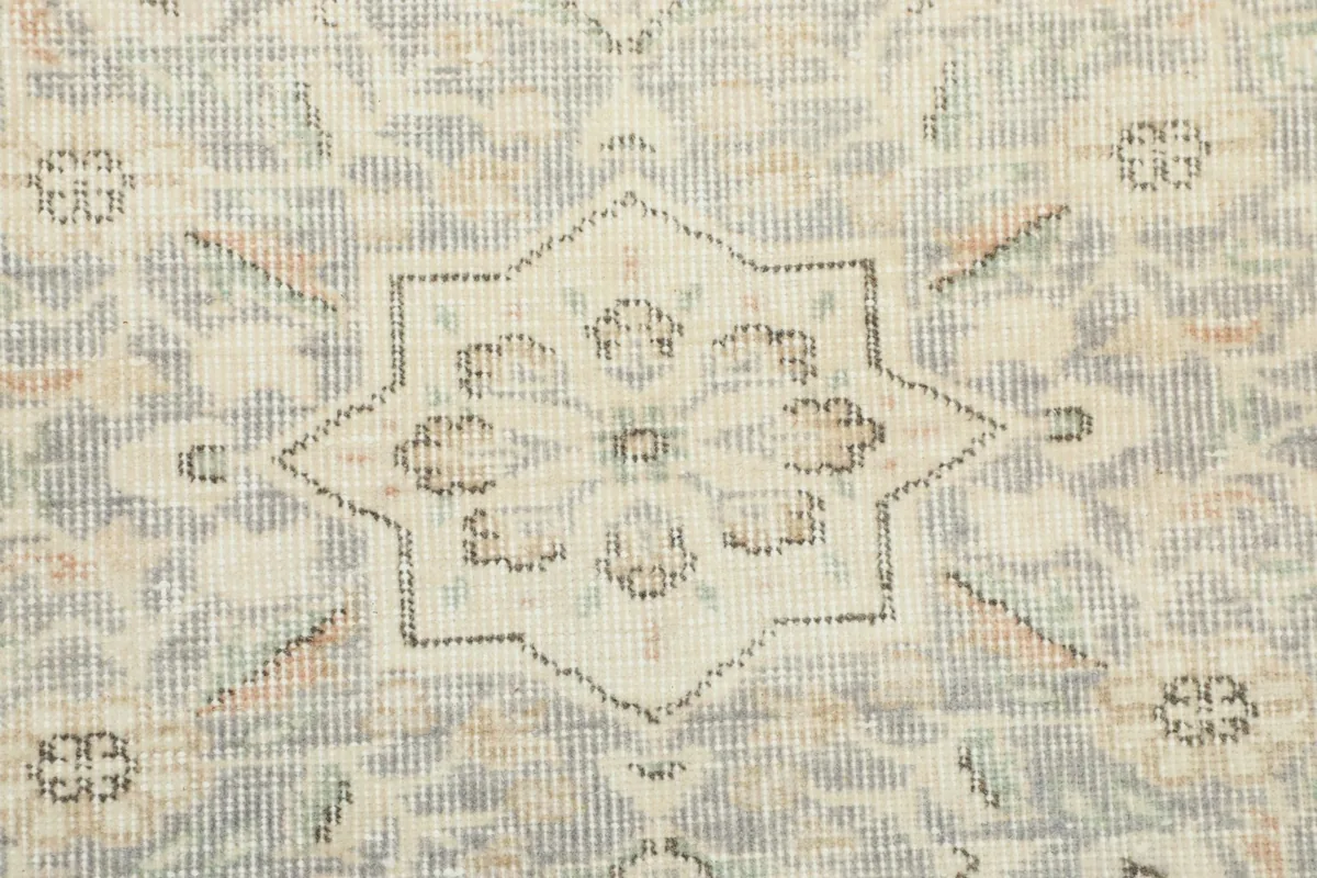 Close-up of the rug's surface, revealing the low pile and vintage wear on the blue and cream fibers