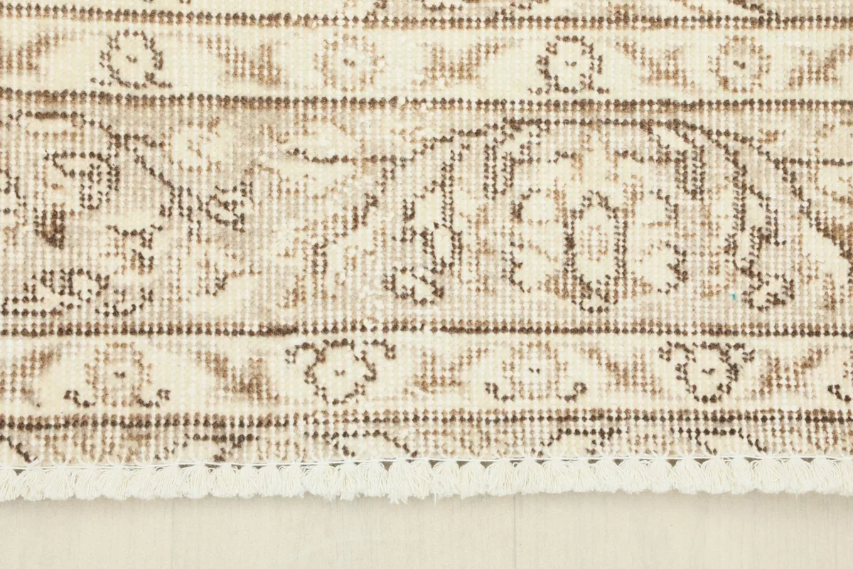 Detail of the rug's border pattern and the short fringe.