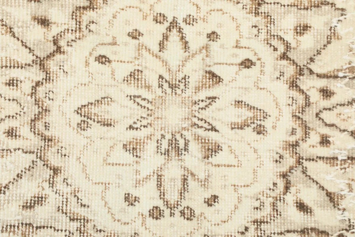 Close-up of the rug's low wool pile and the intricate beige patterns.