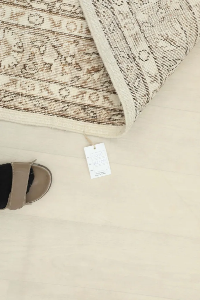 Close-up of the rug's care tag and a sandal for scale.