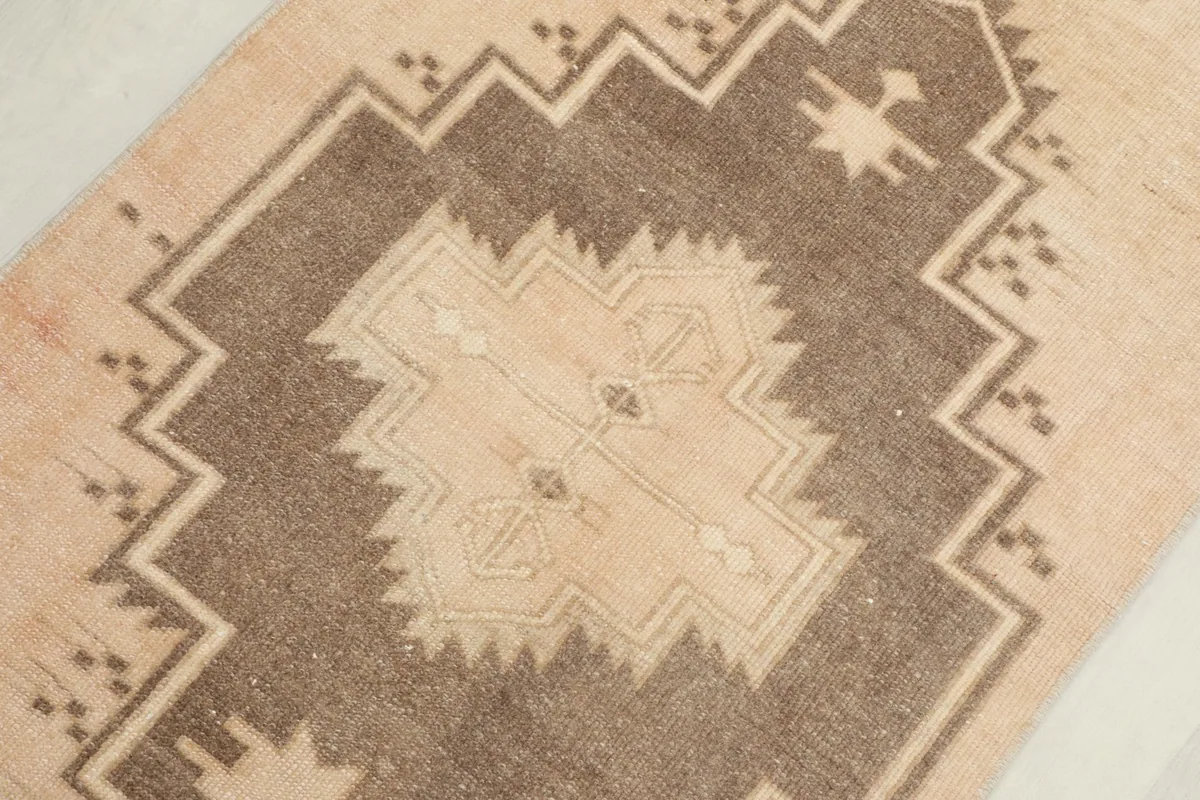 Close-up of a brown and beige geometric motif, showing the texture of the low pile.