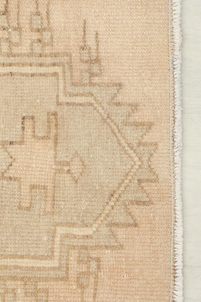 Edge detail of the runner rug, showing the side finishing and part of a geometric pattern.