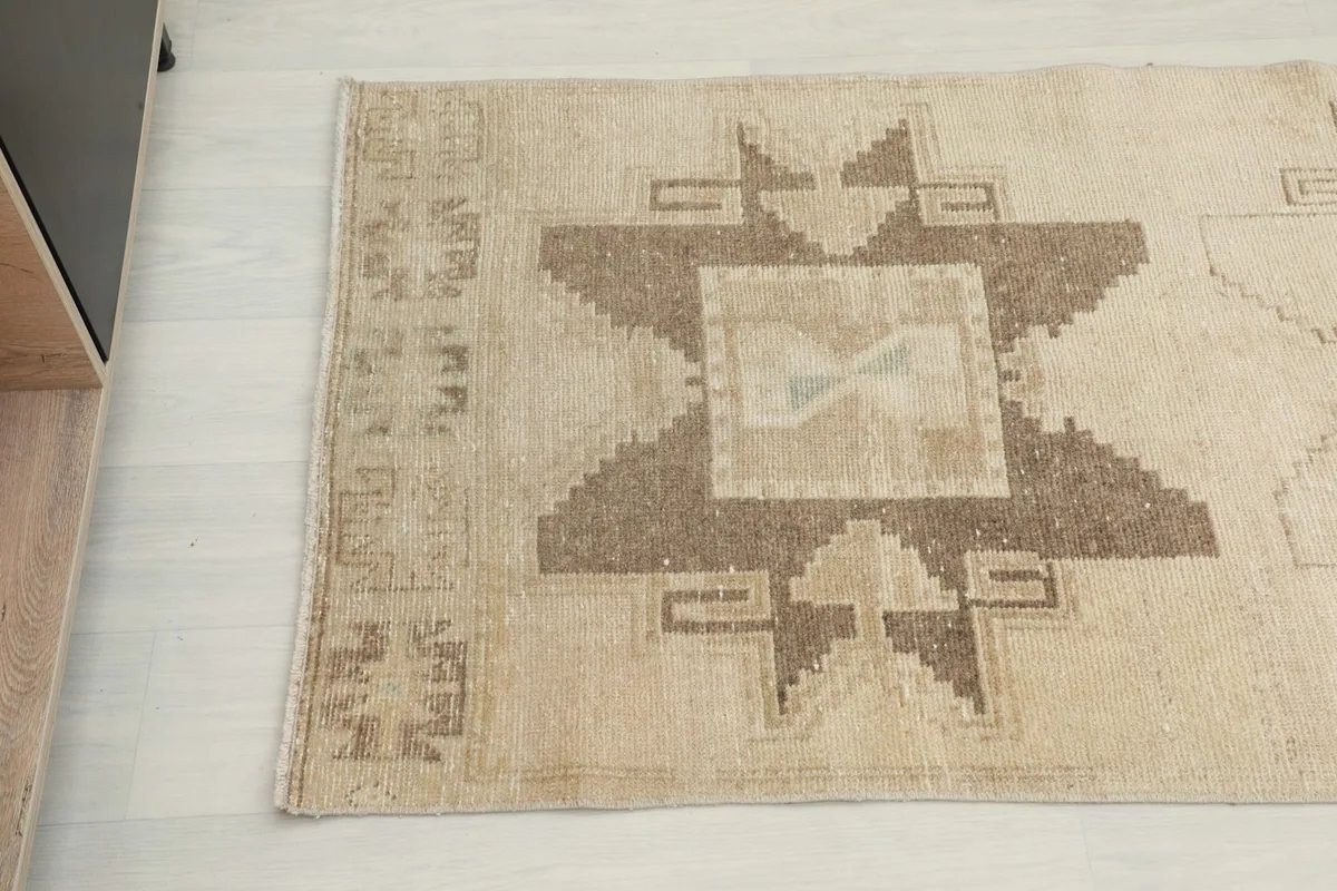 Overhead close-up of the end of the runner rug, showing the brown tribal motifs