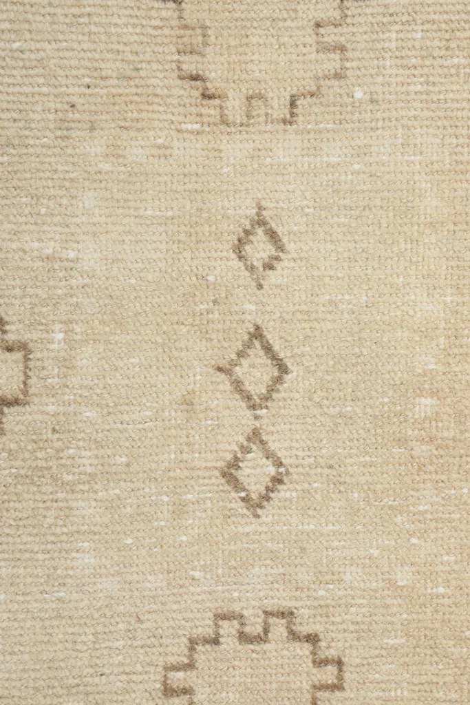 Close-up of the subtle diamonds and other small motifs on the ivory field of the runner