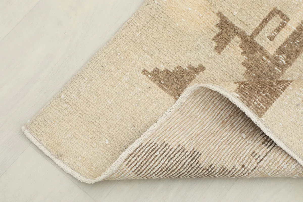 Corner of the runner rug folded to show the back weaving and wool pile texture