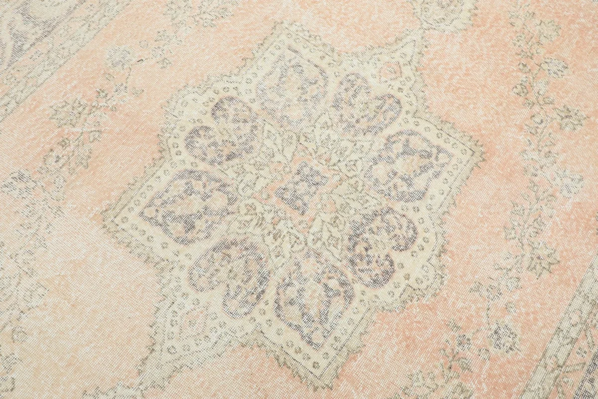 Detailed view of the central medallion, showcasing the intricate geometric and floral patterns in gray and beige.