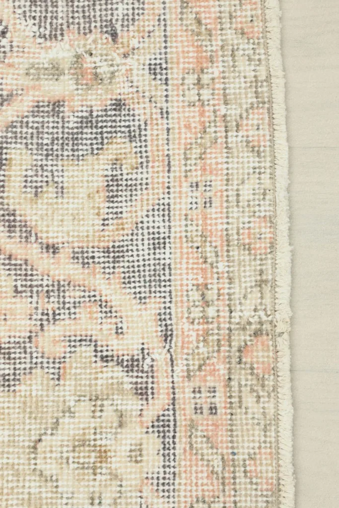 Edge detail of the rug, showing the distinct border design and the professionally finished side.