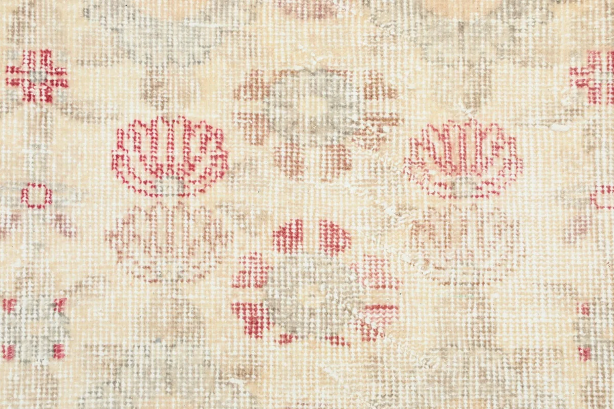 Macro view of the hand-knotted wool pile, showing the texture and colors of the rose motifs.