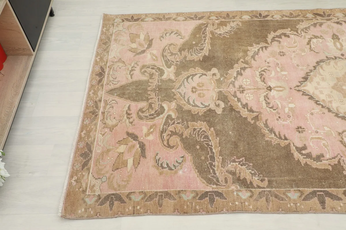 Detail view of the rug's edge and field, revealing the distressed texture and intricate motifs