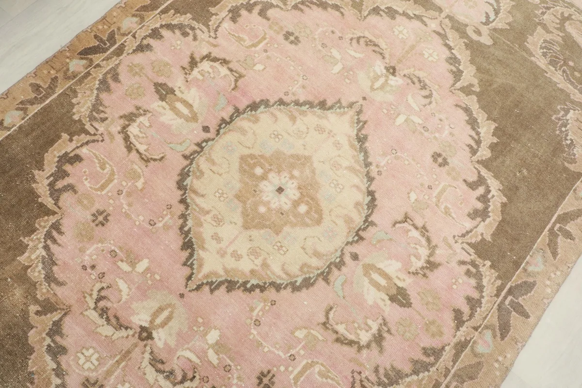 Close-up of the central medallion, showcasing faded rose and ivory tones and fine knotting