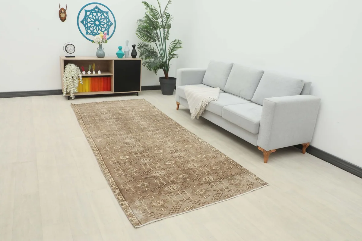 Vintage Anatolian runner rug displayed in a modern living room setting next to a sofa.