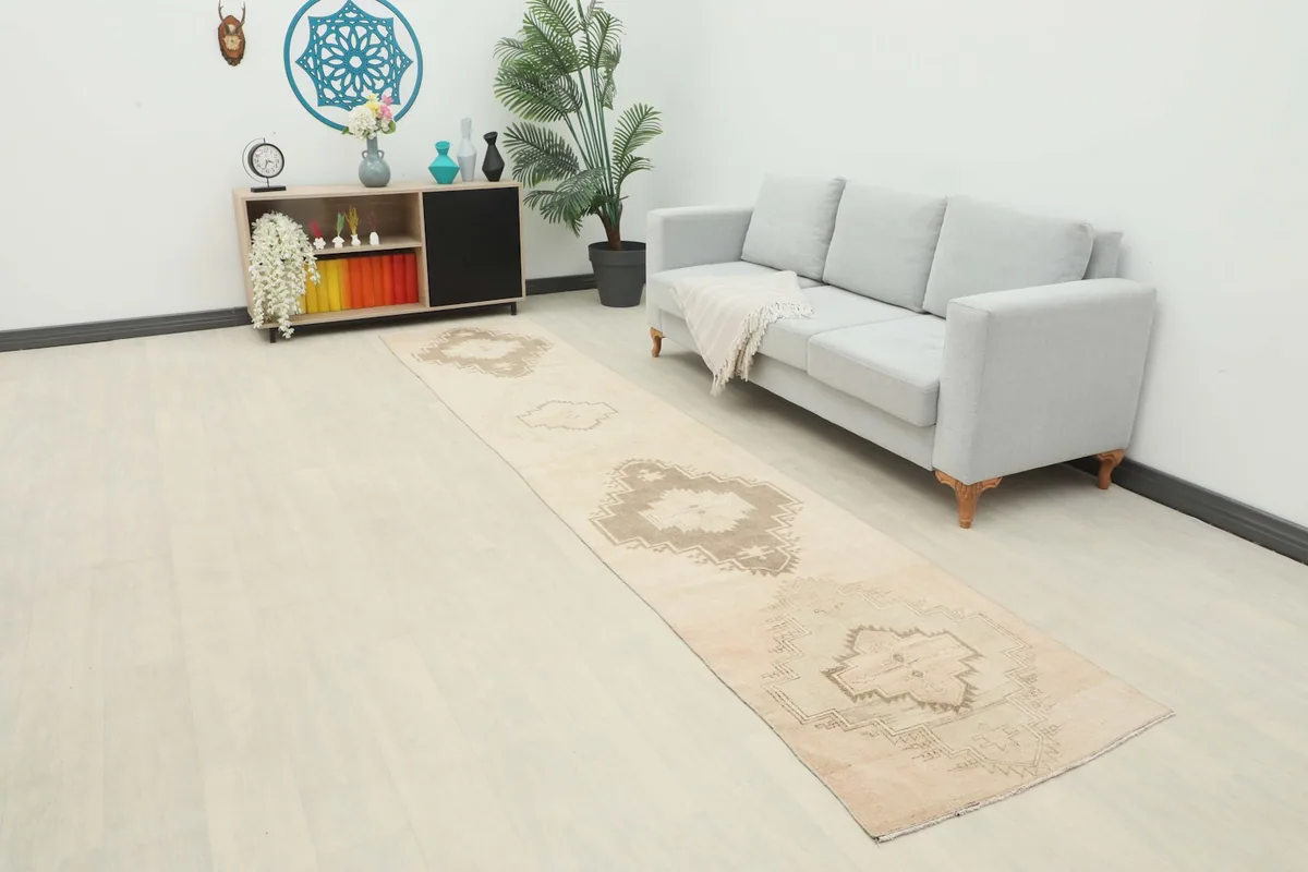 Runner rug in a modern living room setting next to a gray sofa and wooden cabinet