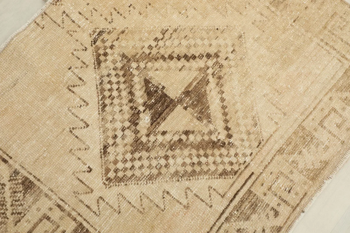 Detailed view of the central diamond pattern and surrounding elements on the rug