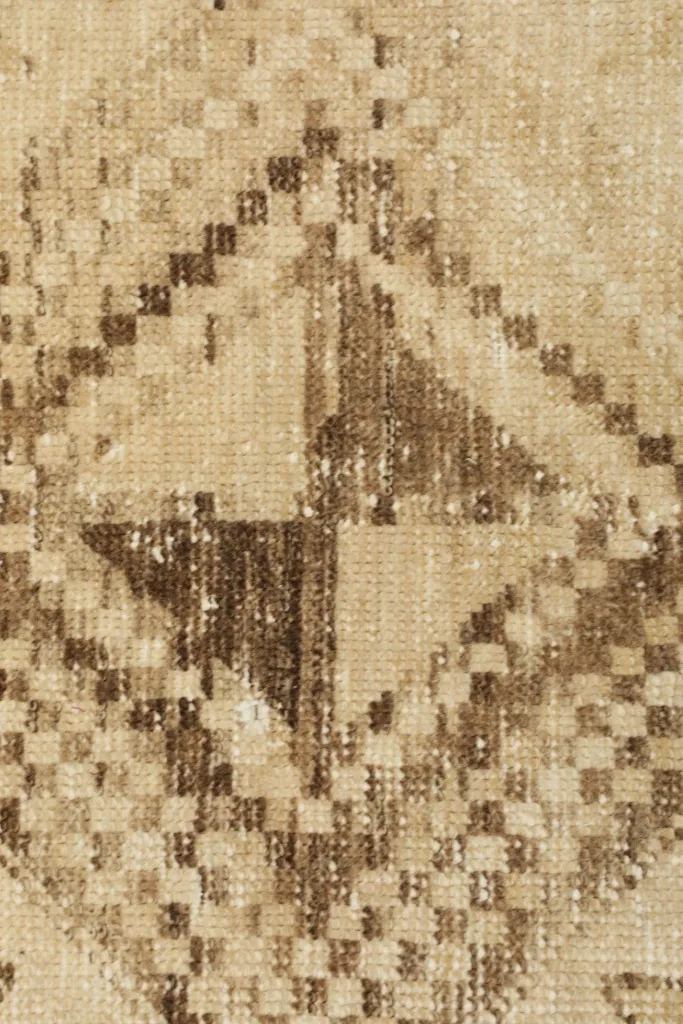 Extreme close-up of the rug's low wool pile and intricate knotting