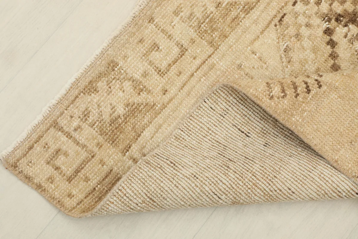 View of the back of the rug, revealing its cotton foundation and hand-knotted construction
