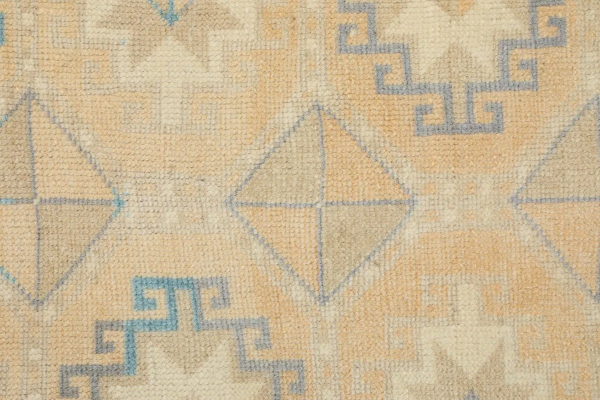 Close-up of the hand-knotted wool pile and intricate geometric diamond patterns