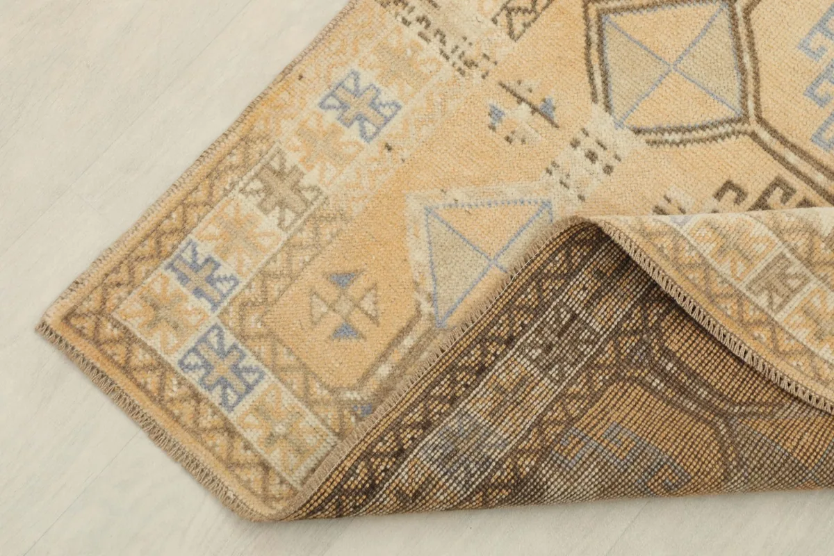 Corner view revealing the reverse side of the hand-knotted wool rug and foundation