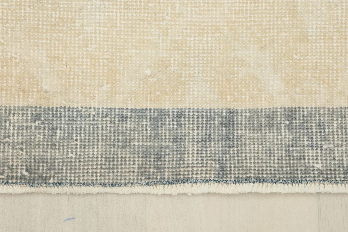Detail of the gray border and the transition to the cream field of the rug