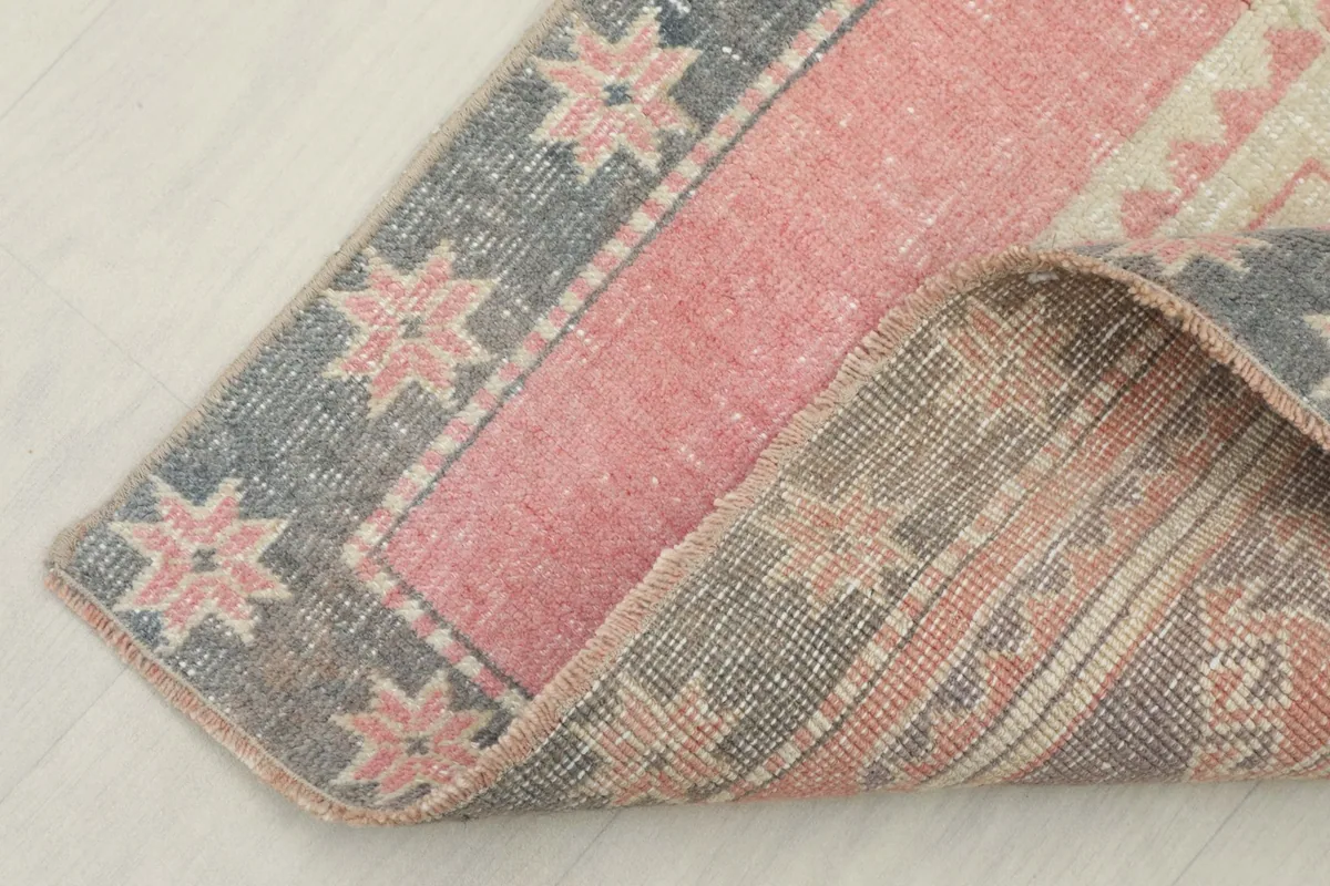 Folded corner of the vintage runner rug showcasing the reverse side and pile texture