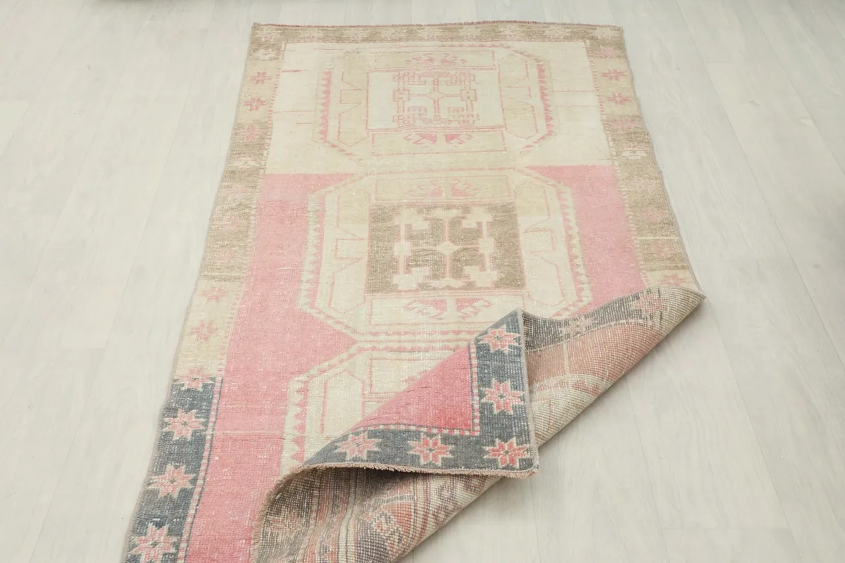 Overhead view of the rug with one corner folded back, revealing the underside and design continuity