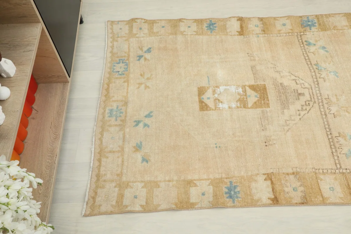 Overhead angled view showing the central motifs and the tan geometric border of the runner.