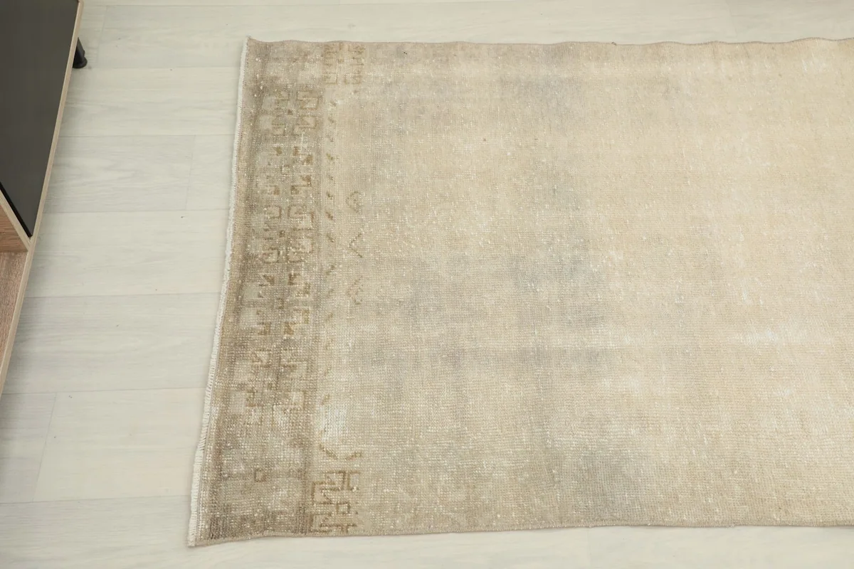 Detail of one end of the runner rug, showing the subtle border design and fringe.