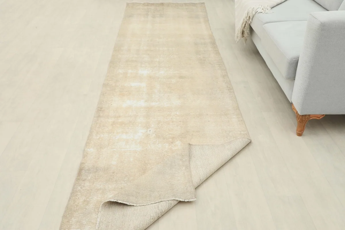 The runner rug partially folded, displaying both the pile and the cotton foundation in a room setting.