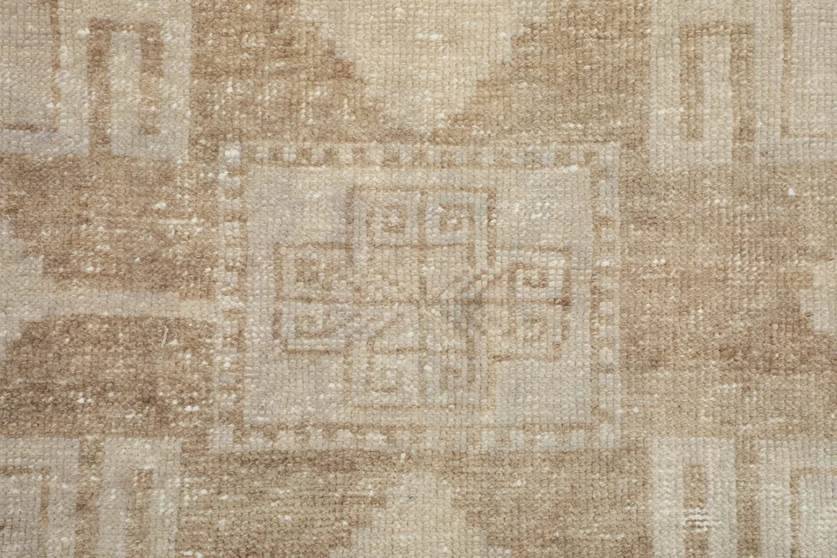 Macro view of the hand-knotted wool pile, showing the texture and intricate details of a central motif