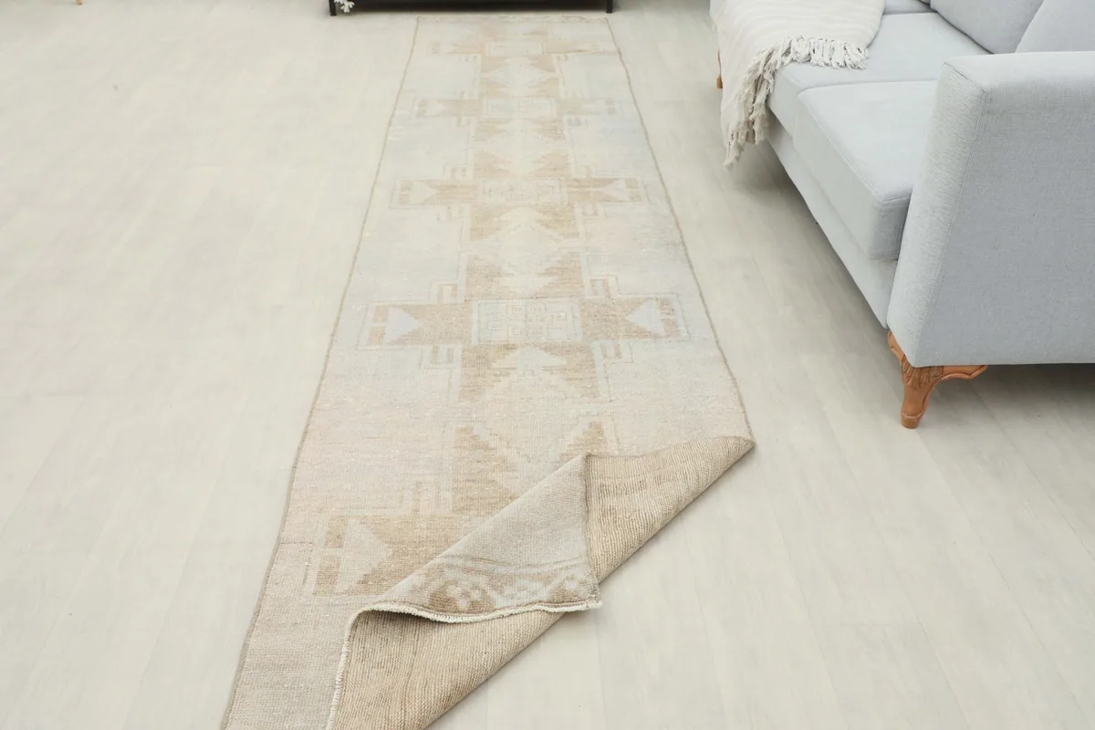 Runner rug partially folded back, showing the consistent weave and the subtle patina