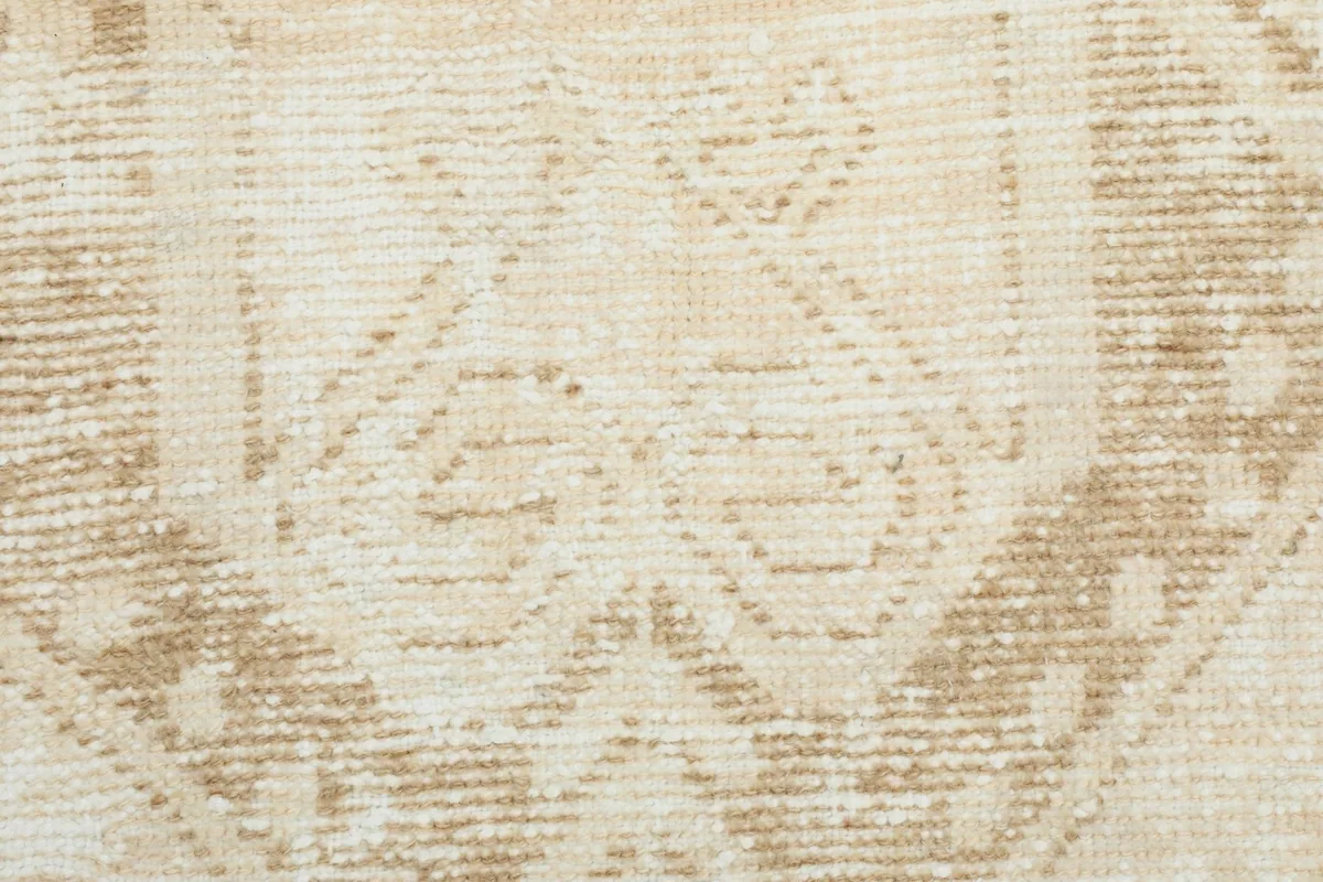 Extreme close-up of the rug's texture and the subtle color variations within the patterns