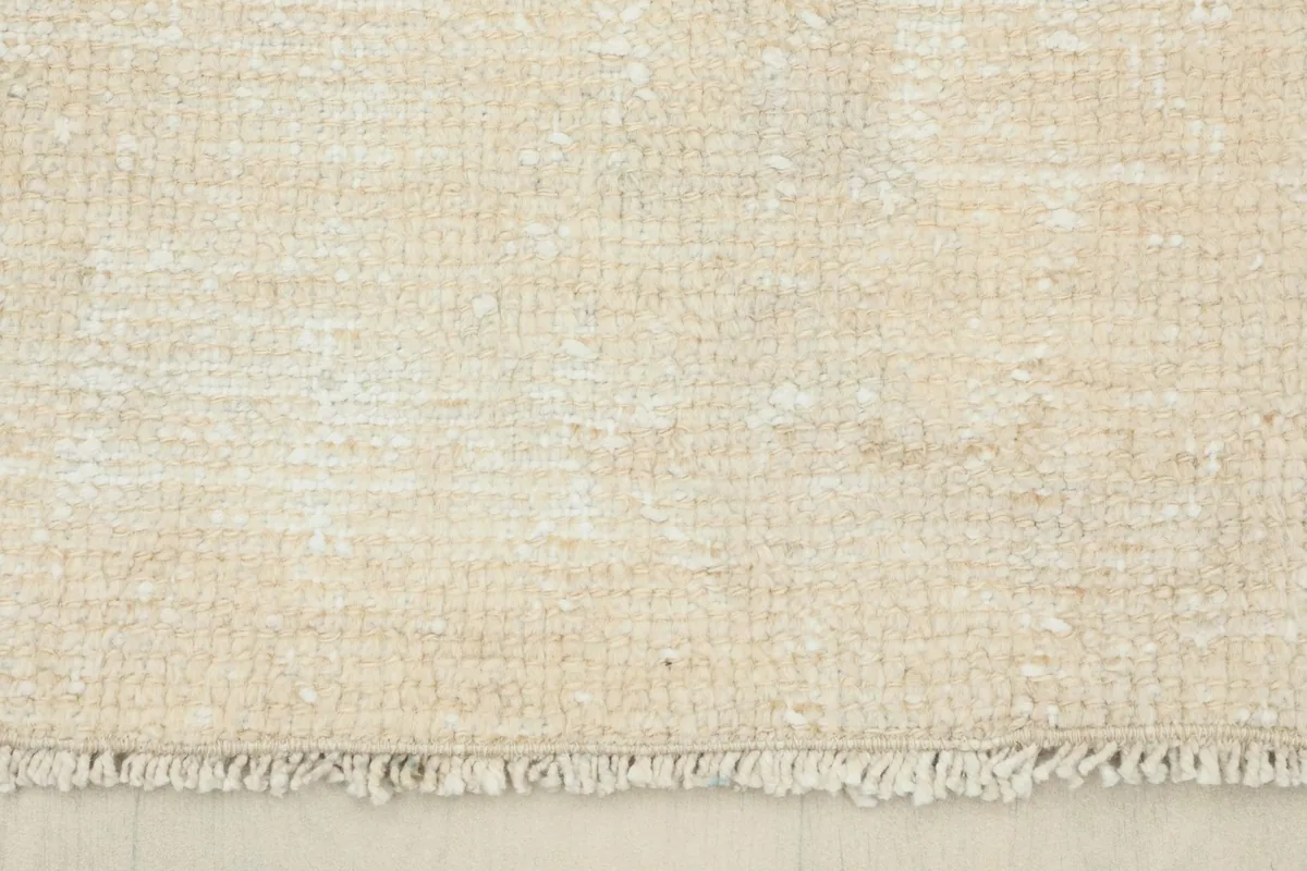 Close-up of the rug's short fringes and the low pile texture at the end