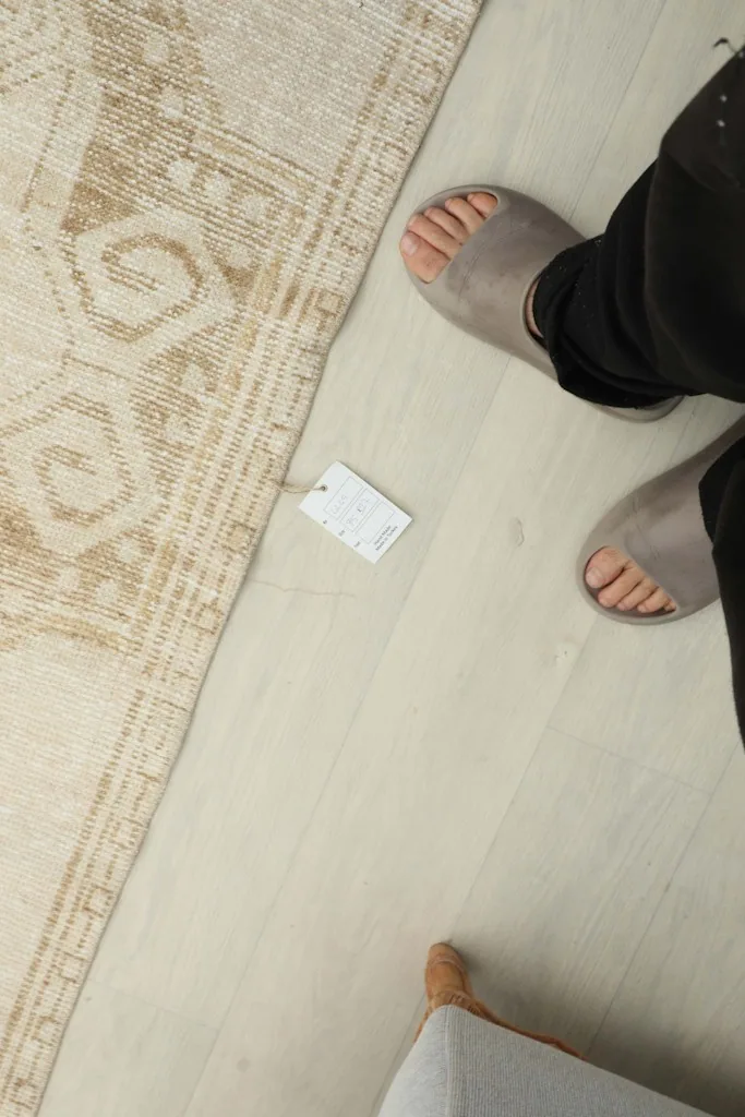 Overhead view of a person's feet next to the rug, indicating its size and scale on the floor