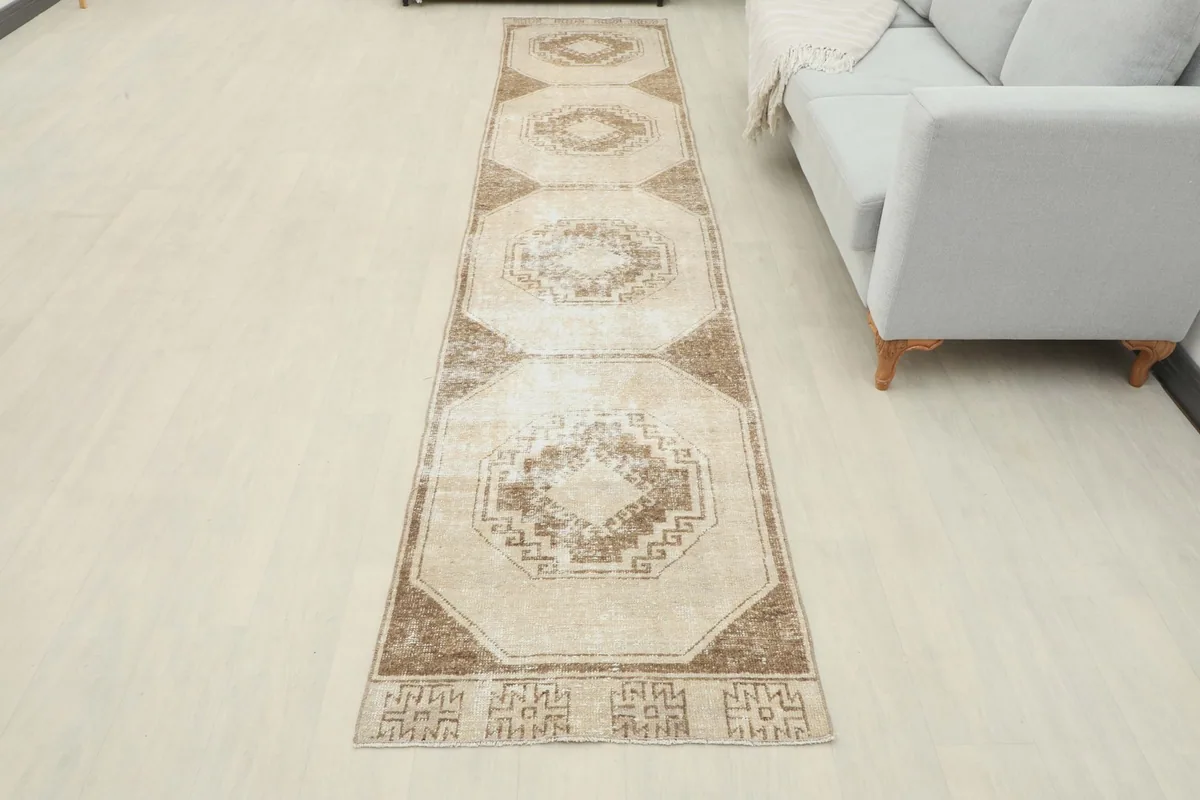 Overhead view of the vintage runner rug laid out in a modern room, next to a sofa