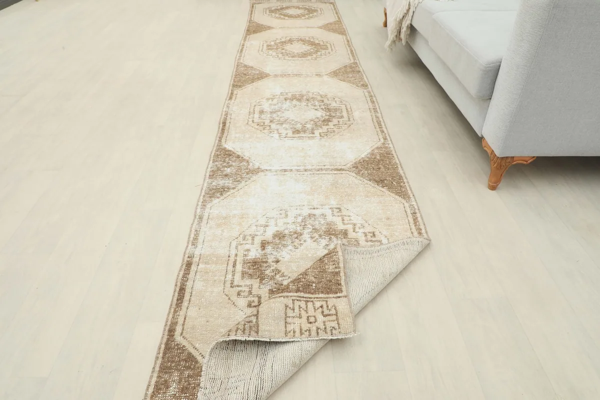 Runner rug partially folded, revealing the underside and the overall length in a room setting