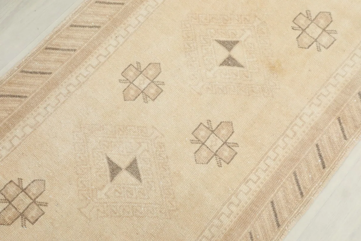 Overhead close-up of the rug's central field, showing repeating gray tribal geometric motifs.