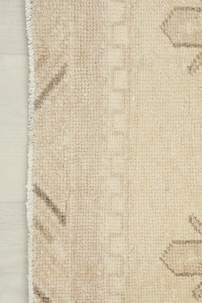 Close-up view of the rug's side edge and detailed border design with striped elements.