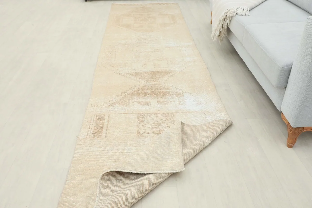 Runner partially folded, revealing the thickness of the wool pile and cotton foundation.