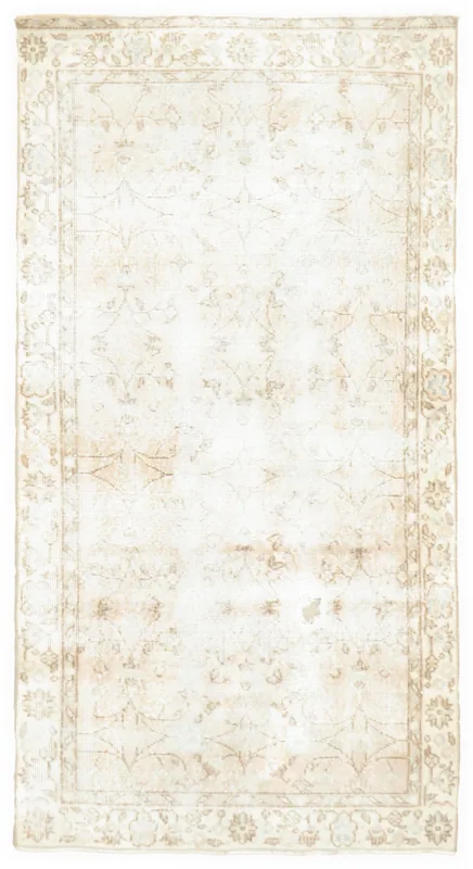 Full overhead view of the beige floral vintage Anatolian area rug on a white background.