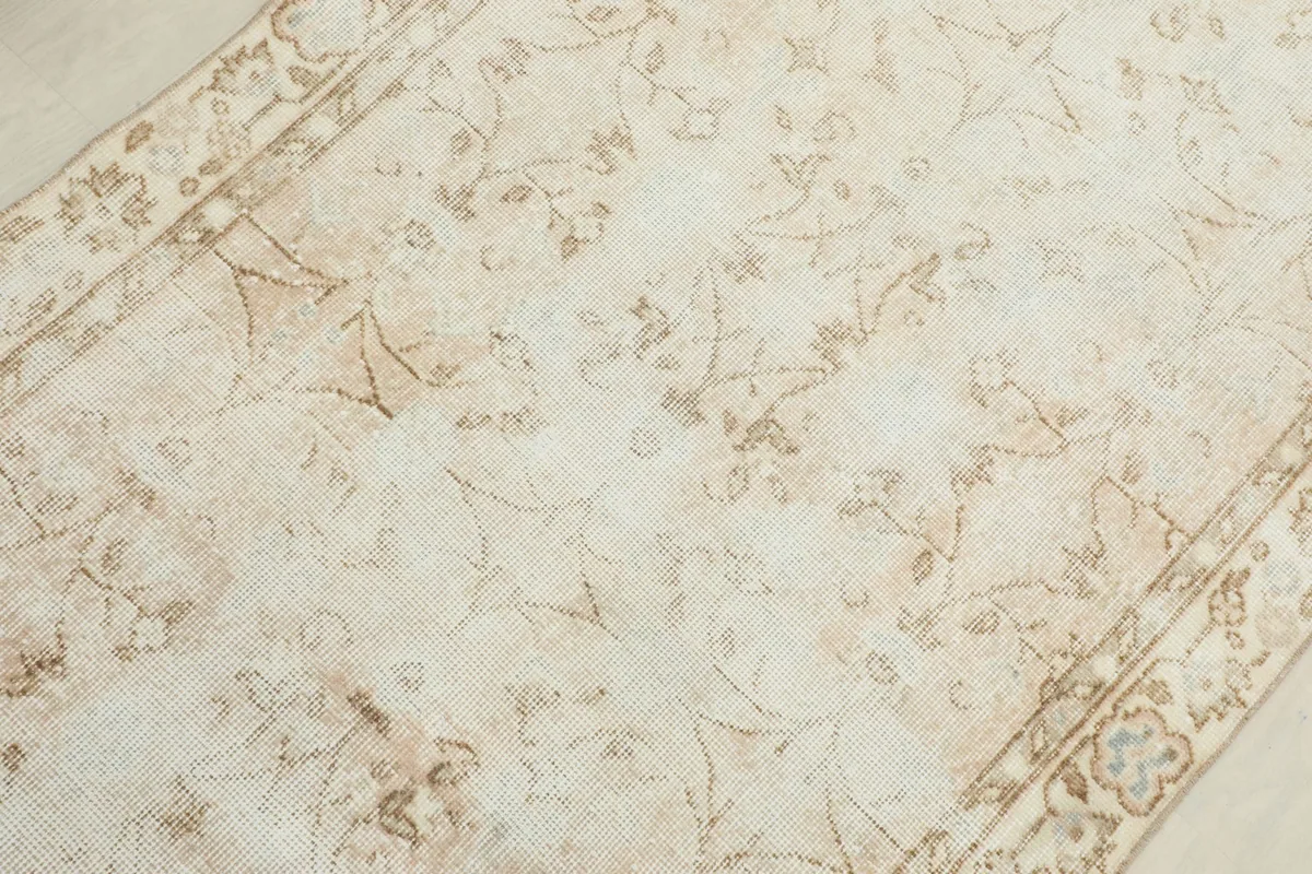 Overhead detail of the rug's central design and border, revealing the gentle patina.