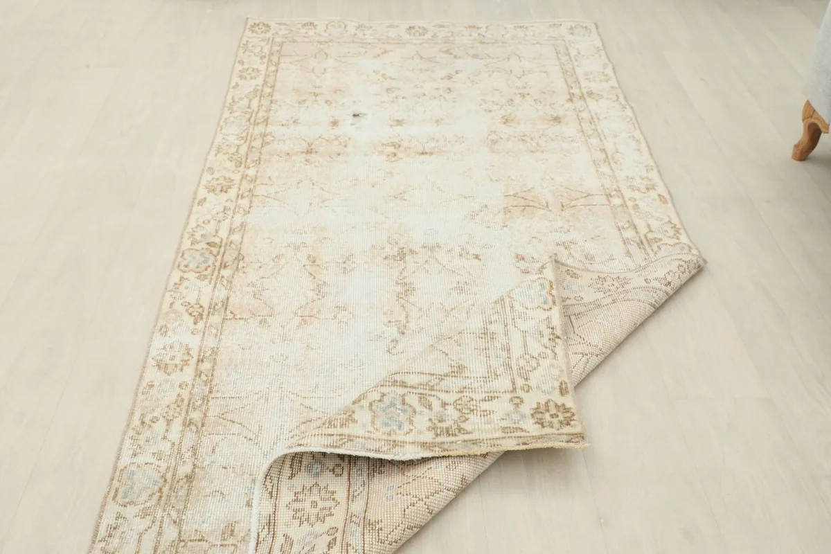 Rug partially folded, revealing the reverse side of the hand-knotted construction.