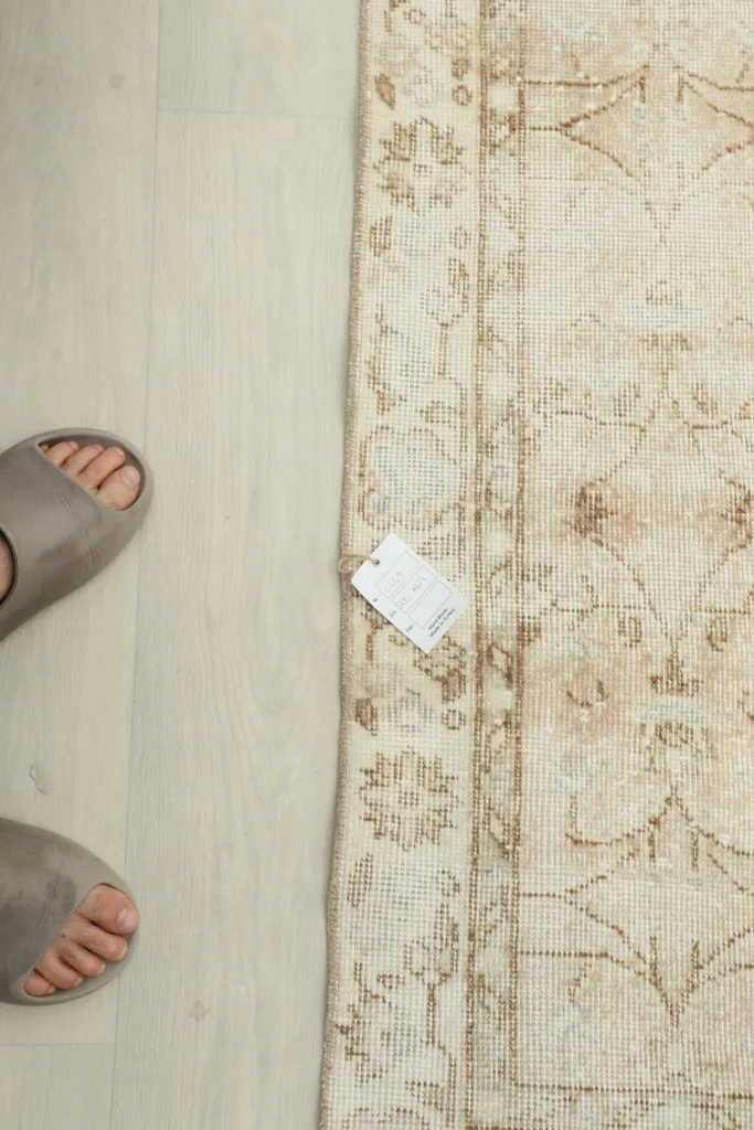 Top-down view of the rug next to feet, indicating scale and texture.