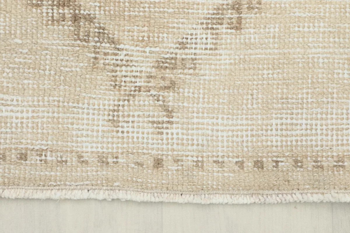 Detail of the short fringe and the hand-knotted edge of the beige Anatolian runner
