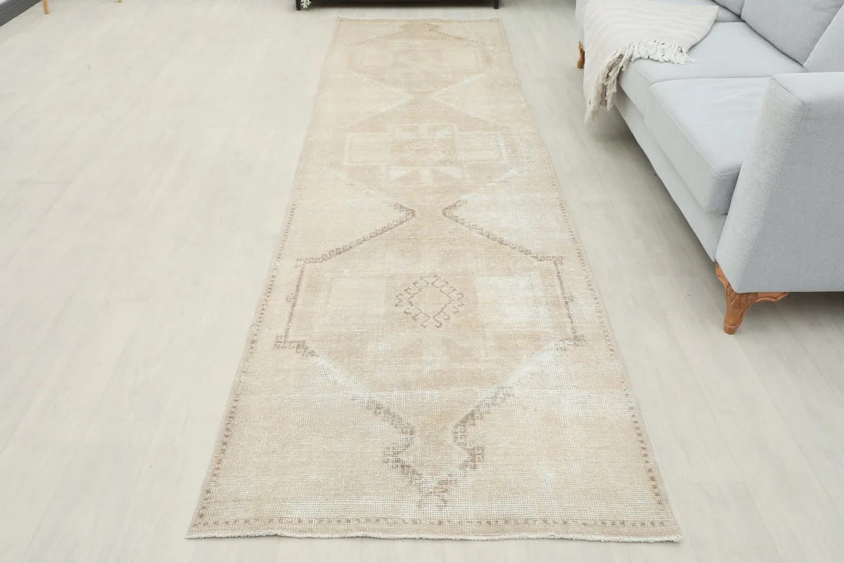 Overhead view of the beige geometric runner rug in a room, highlighting its full length
