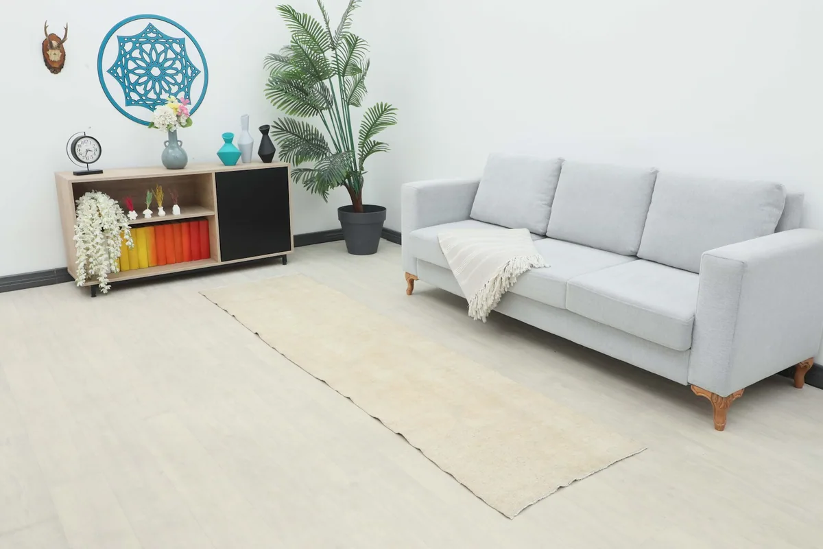 Runner rug in a living room setting with a light gray sofa and modern shelving