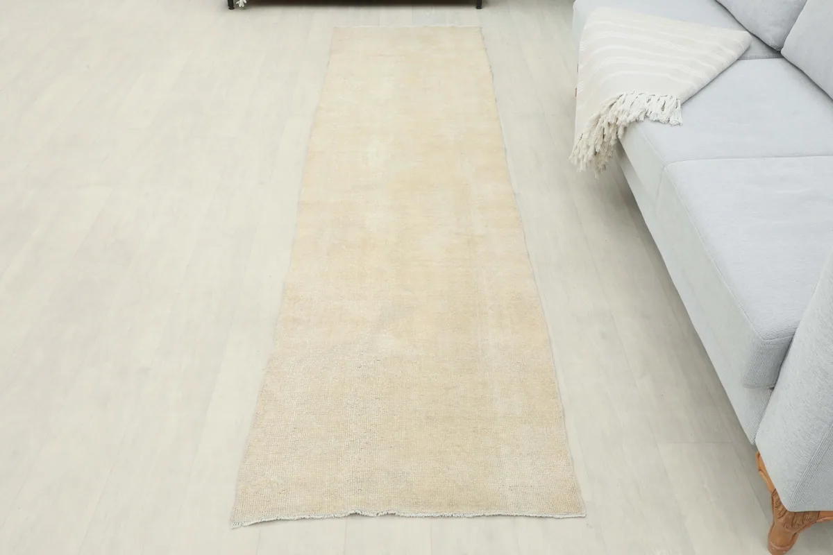 Full room view of the beige runner, centered in a space with a sofa